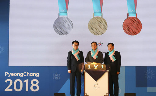 South Korean Culture, Sports and Tourism Minister Do Jong-hwan, center, Pyeongchang Organizing Committee for the 2018 Olympic and Paralympic Winter Games Lee Hee-beom, right, and Gangwon Province Vice Gov. Song Suk-doo stand with the silver, gold and bronze medals for the Pyeongchang 2018 Winter Olympics during an unveiling ceremony in Seoul, South Korea, Thursday, Sept. 21, 2017. South Koreas Pyeongchang is the host city of the winter games which will be held from February 2018. (AP Photo/Lee Jin-man)