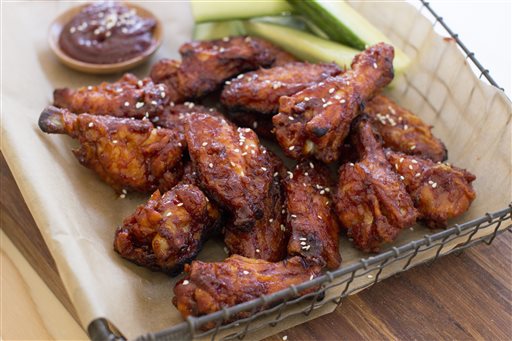 This Dec. 15, 2014 photo shows Korean style chicken wings in Concord, N.H. These wings are made with gochujang, which in Korean cooking is used as a base for stews and marinades, as well as a feisty condiment for one-pot dishes such as bibimbap. (AP Photo/Matthew Mead)