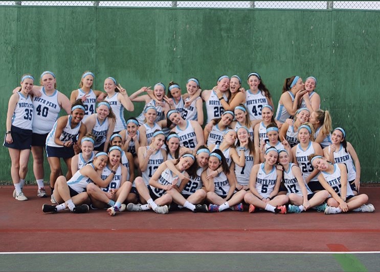 LAX-+The+2017+girls+lacrosse+squad+poses+for+a+picture+in+their+uniforms+on+the+tennis+courts.