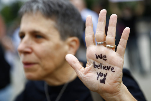 A protester displays a message in support of sexual assault survivors on her palm in front of the Supreme Court on Capitol Hill in Washington, Thursday, Sept. 27, 2018. The Senate Judiciary Committee is scheduled to hear from Supreme Court nominee Brett Kavanaugh and Christine Blasey Ford, the woman who says he sexually assaulted her. (AP Photo/Patrick Semansky)