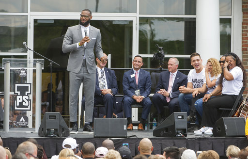 LeBron James speaks and gets a laugh from his mother, Gloria, right, at the opening ceremony for the I Promise School in Akron, Ohio, Monday, July 30, 2018. The I Promise School is supported by the The LeBron James Family Foundation and is run by the Akron Public Schools. (AP Photo/Phil Long)