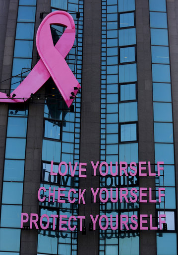 A pink ribbon and a message for breast cancer awareness decorate a building, during a campaign for breast cancer awareness month, in Beirut, Lebanon, Thursday, Oct. 11, 2018. (AP Photo/Hussein Malla)