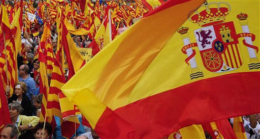 People opposed to the independence of Catalonia hold Catalan and Spanish flags during the holiday known as Dia de la Hispanidad, Spains National Day in Barcelona, Spain, Friday, Oct. 12, 2012. Spain is observing its National Day festivities in somber mood as the traditional military pageant was scaled back to cut costs. Spain is in recession and under pressure to fix its finances while celebrating the day Christopher Columbus discovered America in the name of the Spanish Crown. (AP Photo/Manu Fernandez)