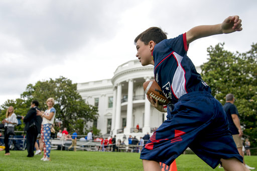 A boy plays flag football during White House Sports and Fitness Day on the South Lawn of the White House, Tuesday, May 29, 2018, in Washington. (AP Photo/Andrew Harnik)