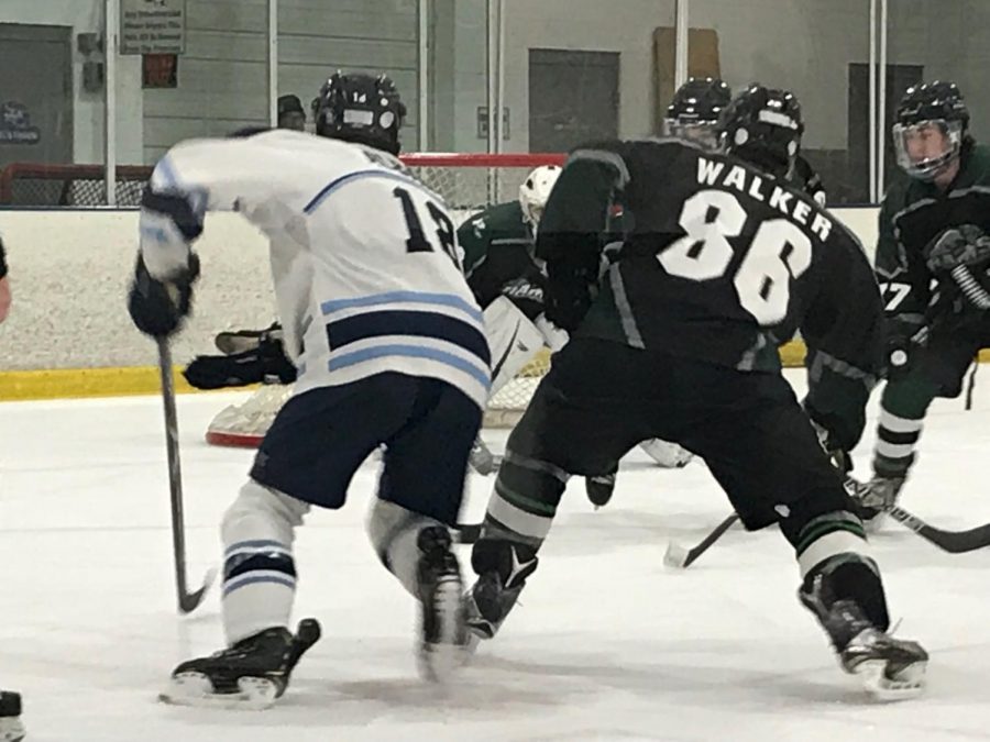 Jared Alabano battles for possession of the puck against a Rams defender 