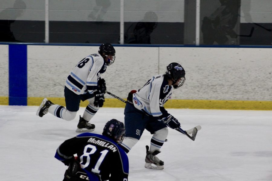 Seniors Albano and Oh track down the puck together. 