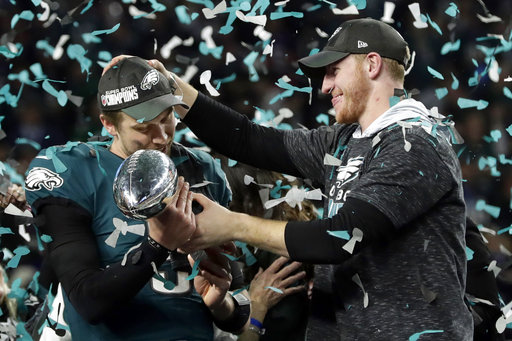 Philadelphia Eagles quarterback Carson Wentz, right, hands the Vincent Lombardi trophy to Nick Foles after winning the NFL Super Bowl 52 football game against the New England Patriots, Sunday, Feb. 4, 2018, in Minneapolis. The Eagles won 41-33. (AP Photo/Frank Franklin II)