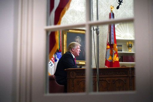 As seen from a window outside the Oval Office, President Donald Trump gives a prime-time address about border security Tuesday, Jan. 8, 2018, at the White House in Washington. (AP Photo/Carolyn Kaster)