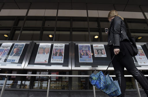 A woman views the front pages of newspapers on display outside the Newseum in Washington, Wednesday, Nov., 9, 2016, the day after the presidential election. (AP Photo/Susan Walsh)