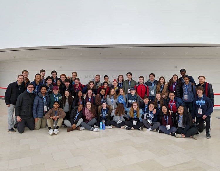 he students pose in front of the sign for the Kauffman Center after warming up for their performances.