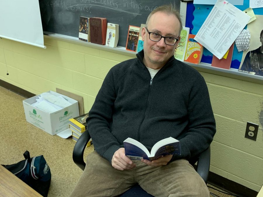 Mr. Mike Lipschutz reading a book at his desk.