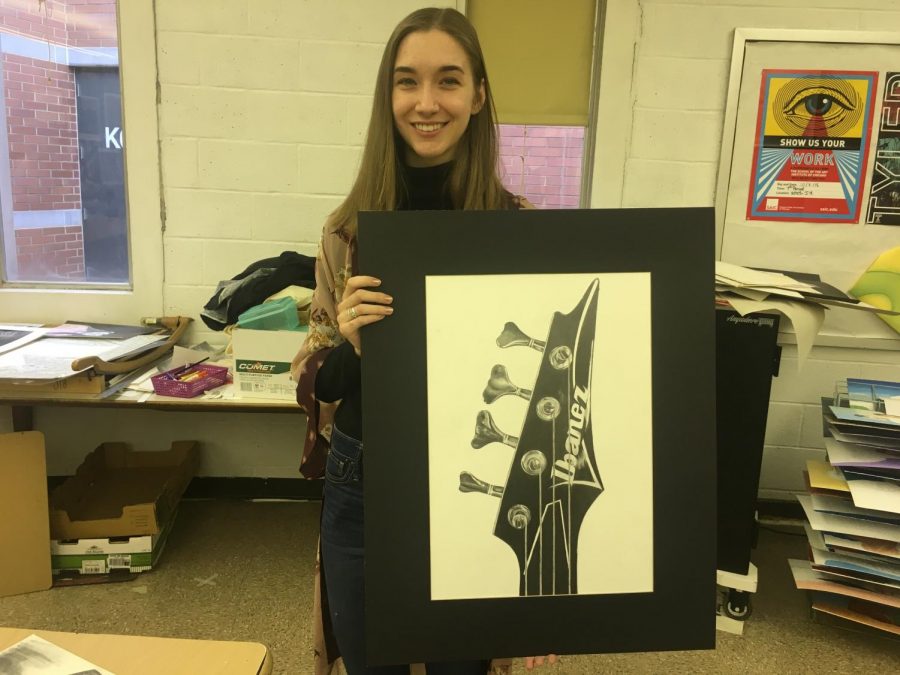 NPHS senior Anna Shinners poses for a picture with an art piece she has been working on this year.