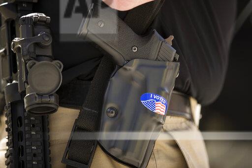 A gun rights advocate with an I VOTED sticker on his holster gathers with others for an annual rally on the steps of the state Capitol in Harrisburg, Pa., Monday, May 6, 2019. (AP Photo/Matt Rourke)