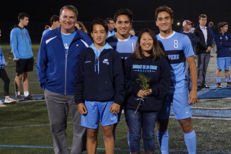 The Stewart family on senior night as Ryan Stewart (middle) and Jamie Stewart (right) have their senior ceremony, with younger brother Alex Stewart (left bottom row) walking with them.