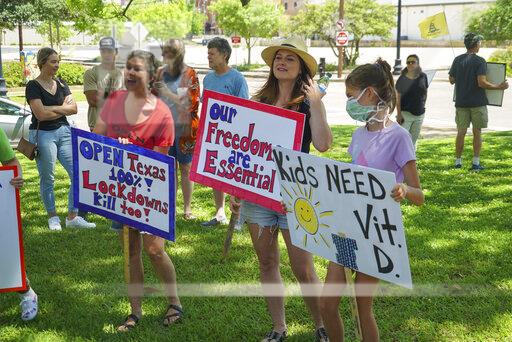 From left: Carrie Bramlette, Kelli Silva and her daughter wave their signs to protest the closure of Texas at the East Texas Freedom Coalitions protest at Tyler City Hall.