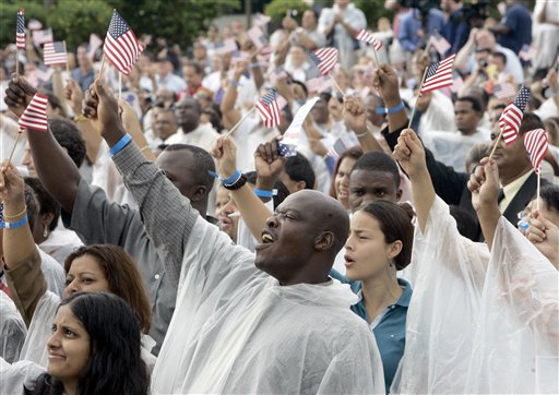 Bianera Petithomme, center, of Haiti, waves a flag and cheers after becoming a U.S. citizen during a naturalization ceremony at Walt Disney World in Lake Buena Vista, Fla., Wednesday, July 4, 2007.  