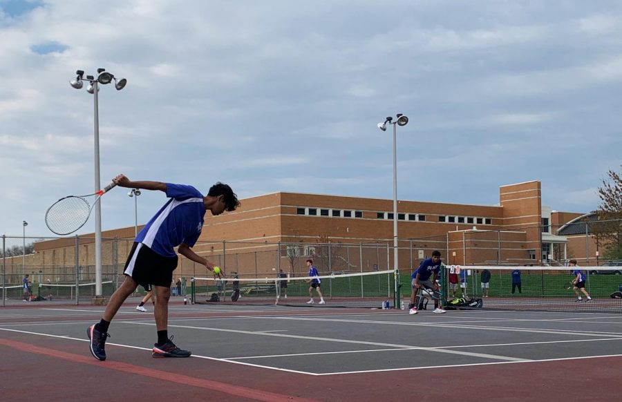 Nikhil Madaka (12) preparing a serve during a doubles match, assisted by Jigar Dadarwala (12) at a April 15th match.