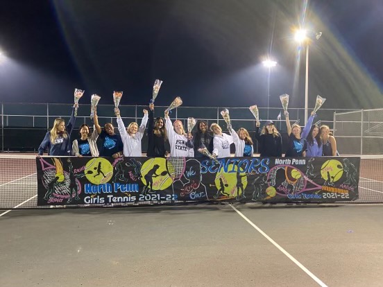 The North Penn girls tennis team celebrating their senior night win