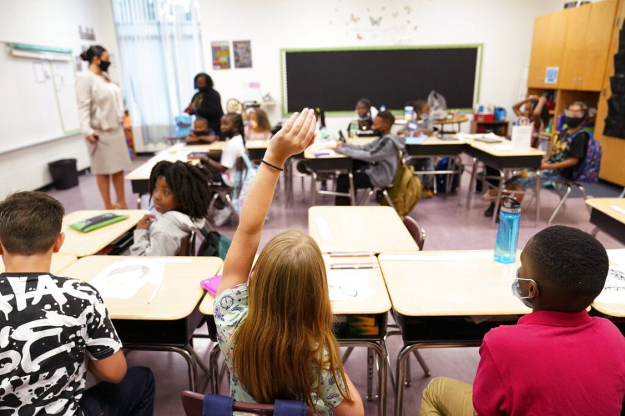 A student raises their hand in a classroom at Tussahaw Elementary school on Wednesday, Aug. 4, 2021, in McDonough, Ga.  Schools have begun reopening in the U.S. with most states leaving it up to local schools to decide whether to require masks. (AP Photo/Brynn Anderson)