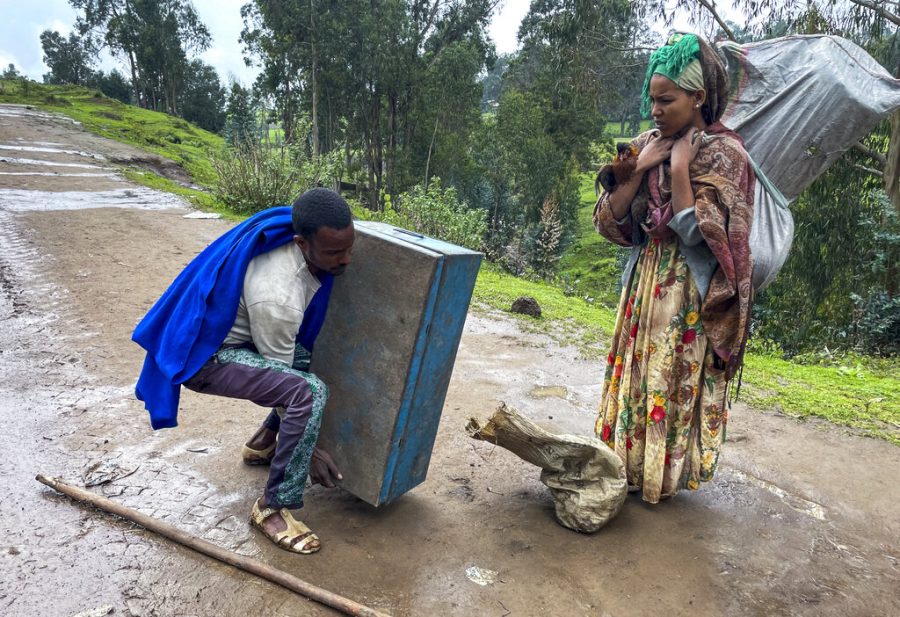 Senait Ambaw, right, who said her home had been destroyed by artillery, leaves by foot on a path near the village of Chenna Teklehaymanot, in the Amhara region of northern Ethiopia, on Sept. 9, 2021. (AP Photo)