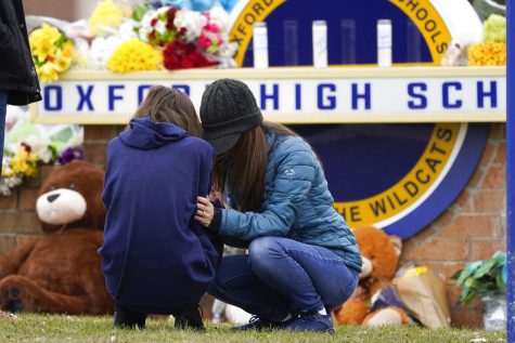 Mourners grieve at Oxford High School in Oxford, Mich., Wednesday, Dec. 1, 2021. Authorities say a 15-year-old sophomore opened fire at Oxford High School, killing four students and wounding seven other people on Tuesday. (AP Photo/Paul Sancya)