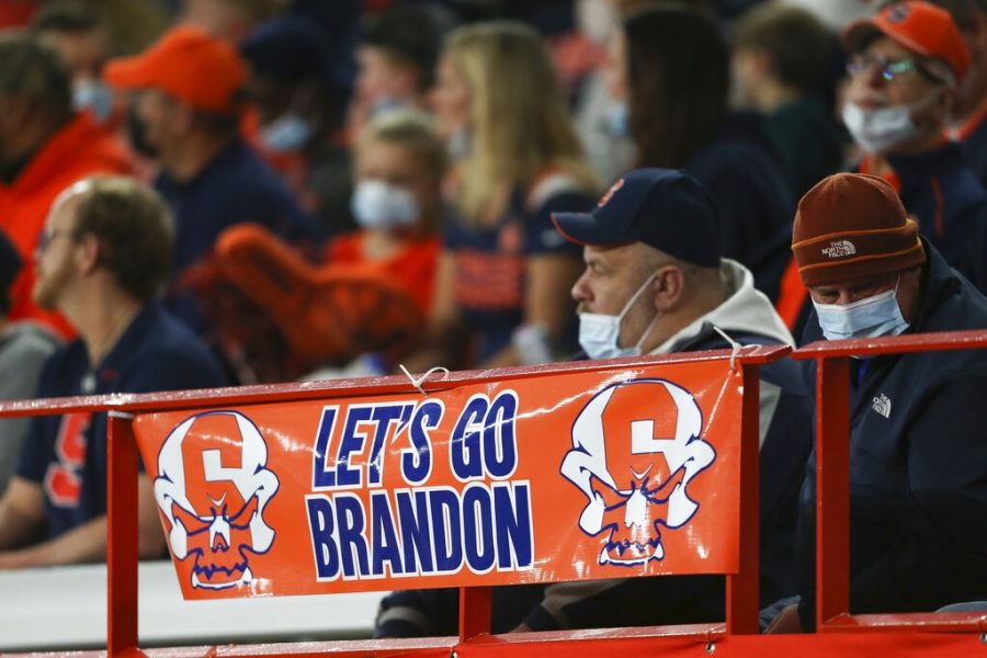 A sign reading Lets go Brandon is displayed on the railing in the first half of an NCAA college football game between Boston College and Syracuse in Syracuse, N.Y., Saturday, Oct. 30, 2021. Critics of President Joe Biden have come up with the cryptic new phrase to insult the Democratic president. (AP Photo/Joshua Bessex)