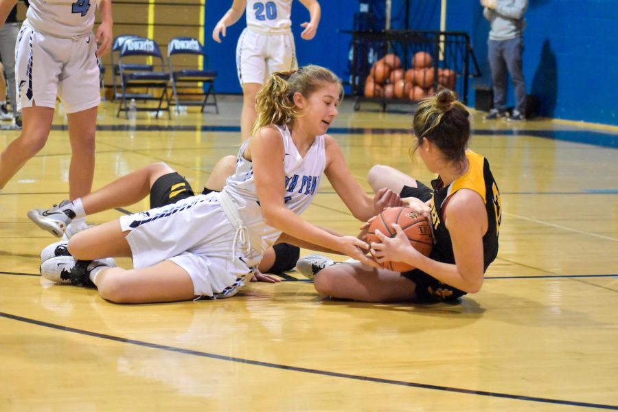 Sophmore Caleigh Sperling fights for the ball against CB Wests Emily Spratt in the girls basketball teams first game of the season.
