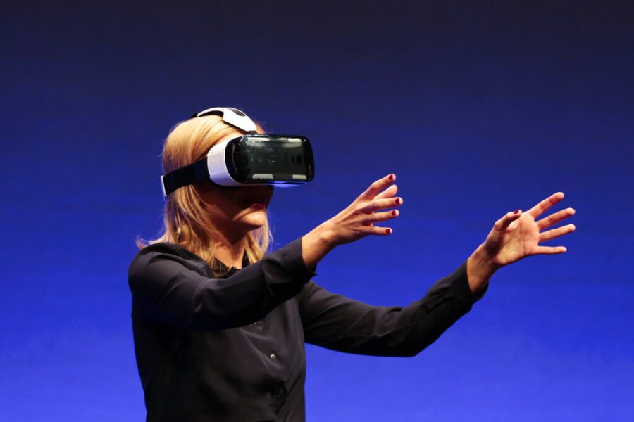 In this September 3, 2014 file photo, British television presenter Rachel Riley shows a virtual-reality headset called Gear VR during an unpacked event of Samsung ahead of the consumer electronic fair IFA in Berlin. (AP Photo/Markus Schreiber, file)