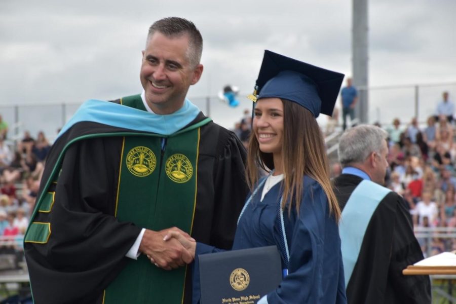 Dr.+Todd+Bauer+presents+a+diploma+to+NPHS+graduate+Bella+Botero+at+the+2021+NPHS+commencement+ceremony.+