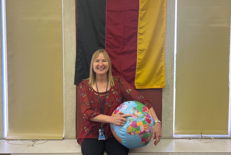 Moll sit proudly in front of the German Flag in her classroom.