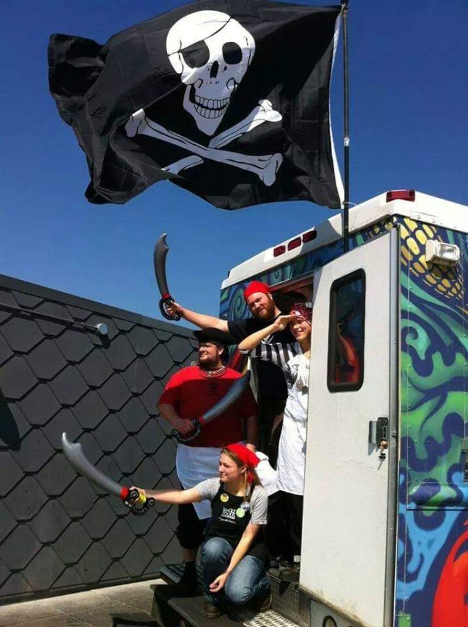 Raab (red shirt) poses with his food truck crew dressed like pirates.