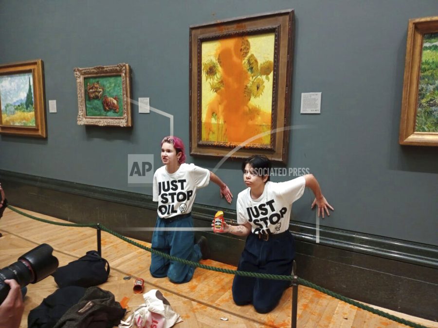 Handout+photo+issued+by+Just+Stop+Oil+of+two+protesters+who+have+thrown+tinned+soup+at+Vincent+Van+Goghs+famous+1888+work+Sunflowers+at+the+National+Gallery+in+London%2C+Friday+Oct.+14%2C+2022.+The+group+Just+Stop+Oil%2C+which+wants+the+British+government+to+halt+new+oil+and+gas+projects%2C+said+activists+dumped+two+cans+of+Heinz+tomato+soup+over+the+oil+painting+on+Friday.+London%E2%80%99s+Metropolitan+Police+said+officers+arrested+two+people+on+suspicion+of+criminal+damage+and+aggravated+trespass.+%28Just+Stop+Oil+via+AP%29