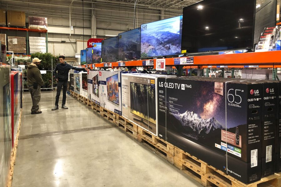 Two men compare television brands LG, Samsung, TCL, Sony and Vizio, while shopping at a retail store, Monday, May 13, 2019, in New Rochelle, N.Y. (AP Photo/Julie Jacobson)