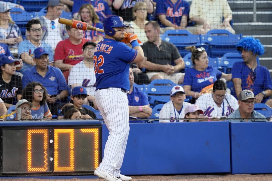 The pitch clock runs as New York Mets Daniel Vogelbach (32) warms up on deck during the fifth inning of a spring training baseball game against the St. Louis Cardinals, Saturday, March 25, 2023, in Port St. Lucie, Fla. (AP Photo/Lynne Sladky)