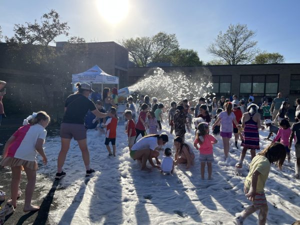 North Wales Elementary School students happily run around in the soapy foam at the playground party.