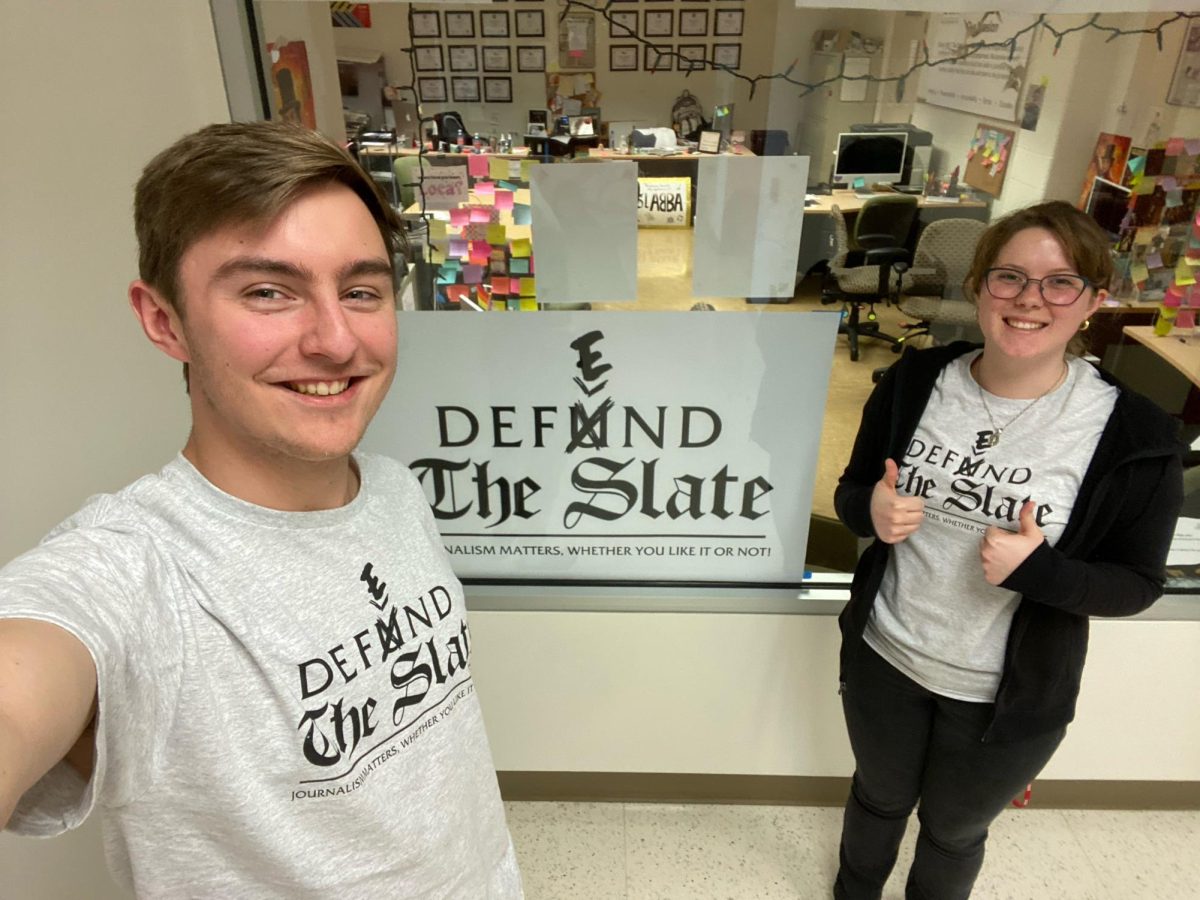 DEFUND/DEFEND THE SLATE: Seen above are editors Connor Niszcak (left) and Elizabeth Peters (right) and their design of the “Defund/Defend The Slate” t-shirts which served as a response to some on-campus backlash for reporting on fraternity hazing at Shippensburg University. 		
