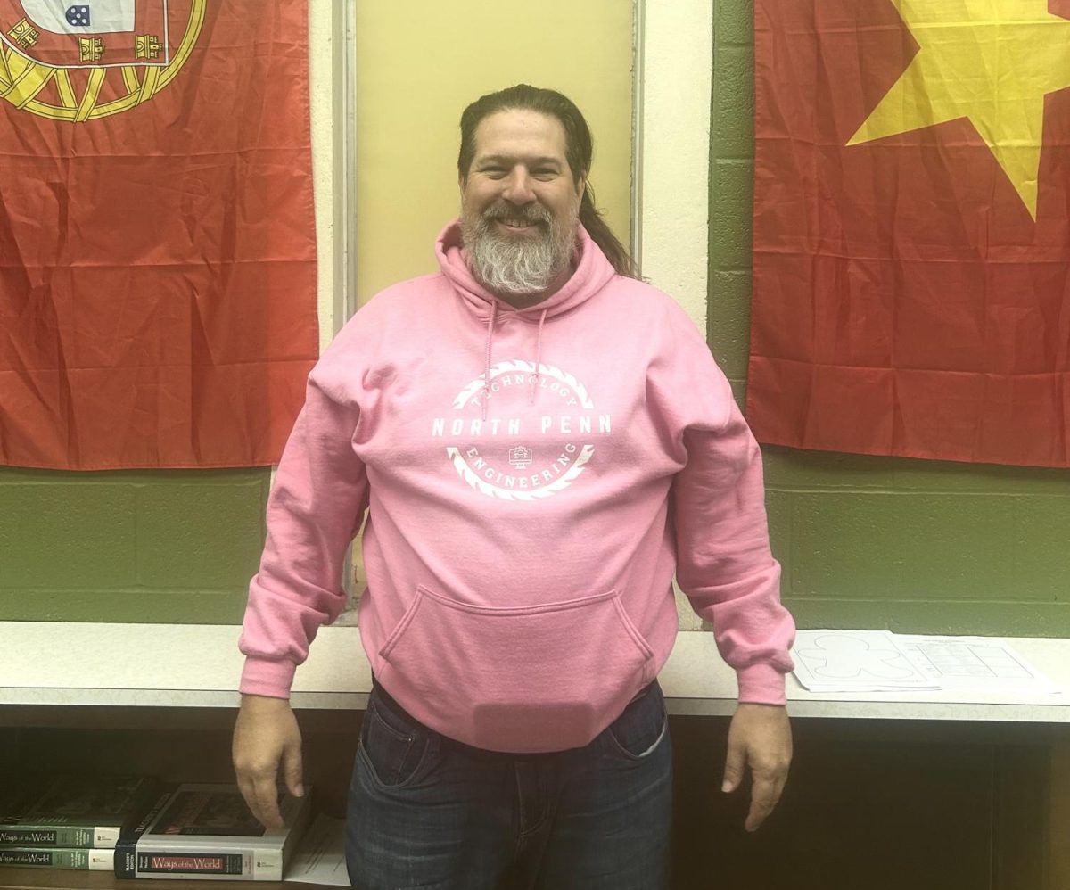 All Around the World: Mr. Joel Evans stands between Vietnam and Portugal flags in his AP World History classroom. 