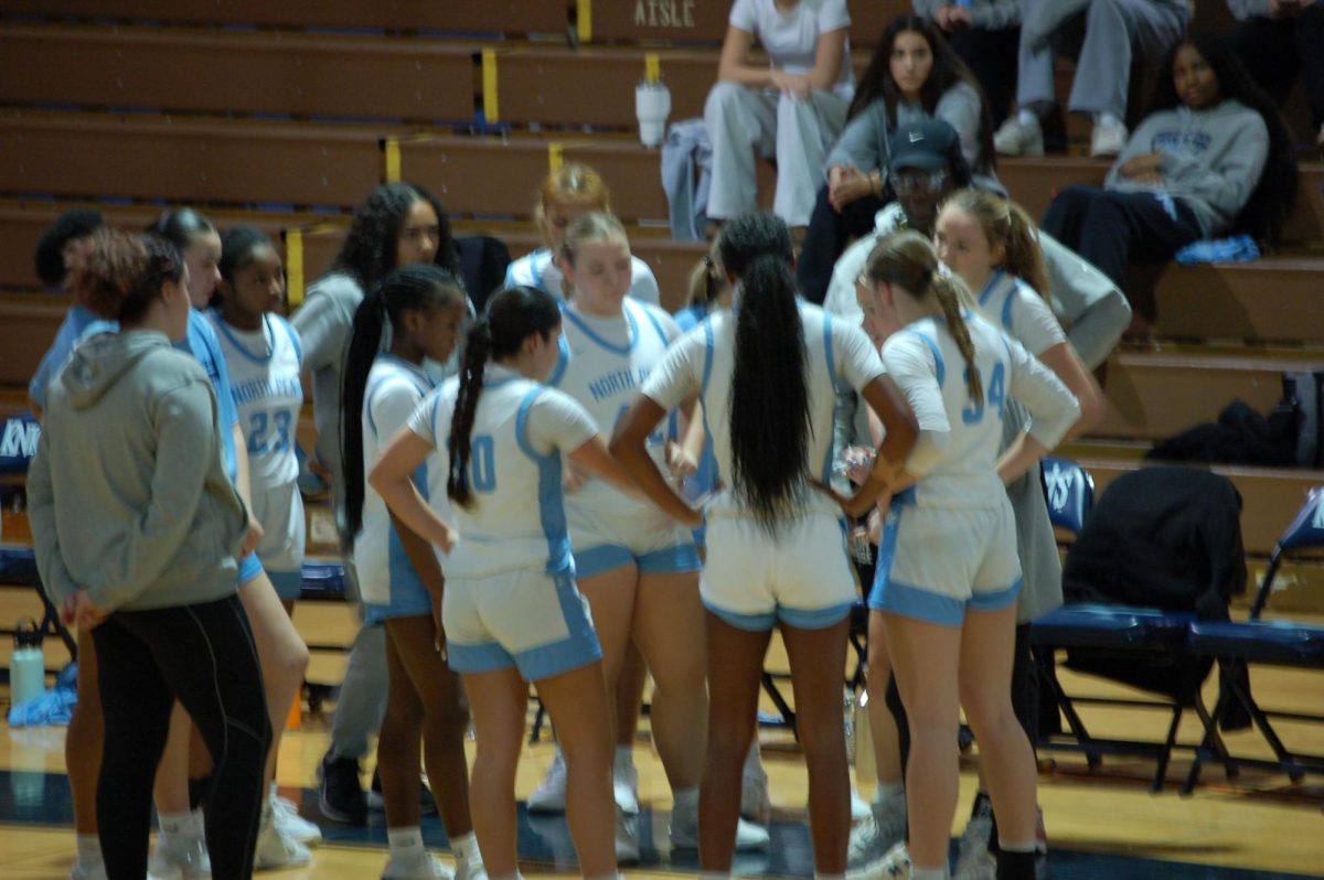 The Knights huddle around head coach Bri Cullen during a timeout.