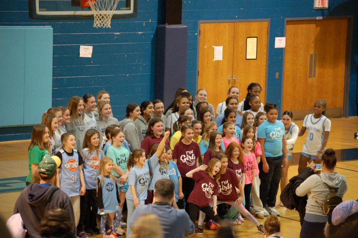  North Penn girls basketball team posing with young hoopers in the community.